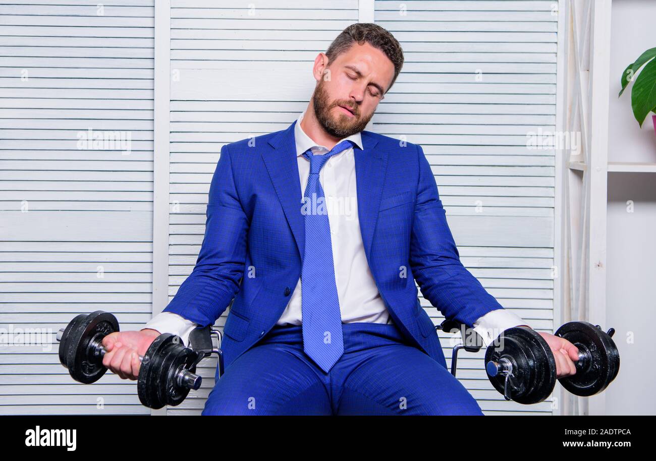 Downcast concept. Despondent by work. Feel tension in muscles. Pressure tension stress. Mental and emotional tension. Man raise heavy dumbbells. Businessman manager exhausted. Sport healthy lifestyle. Stock Photo