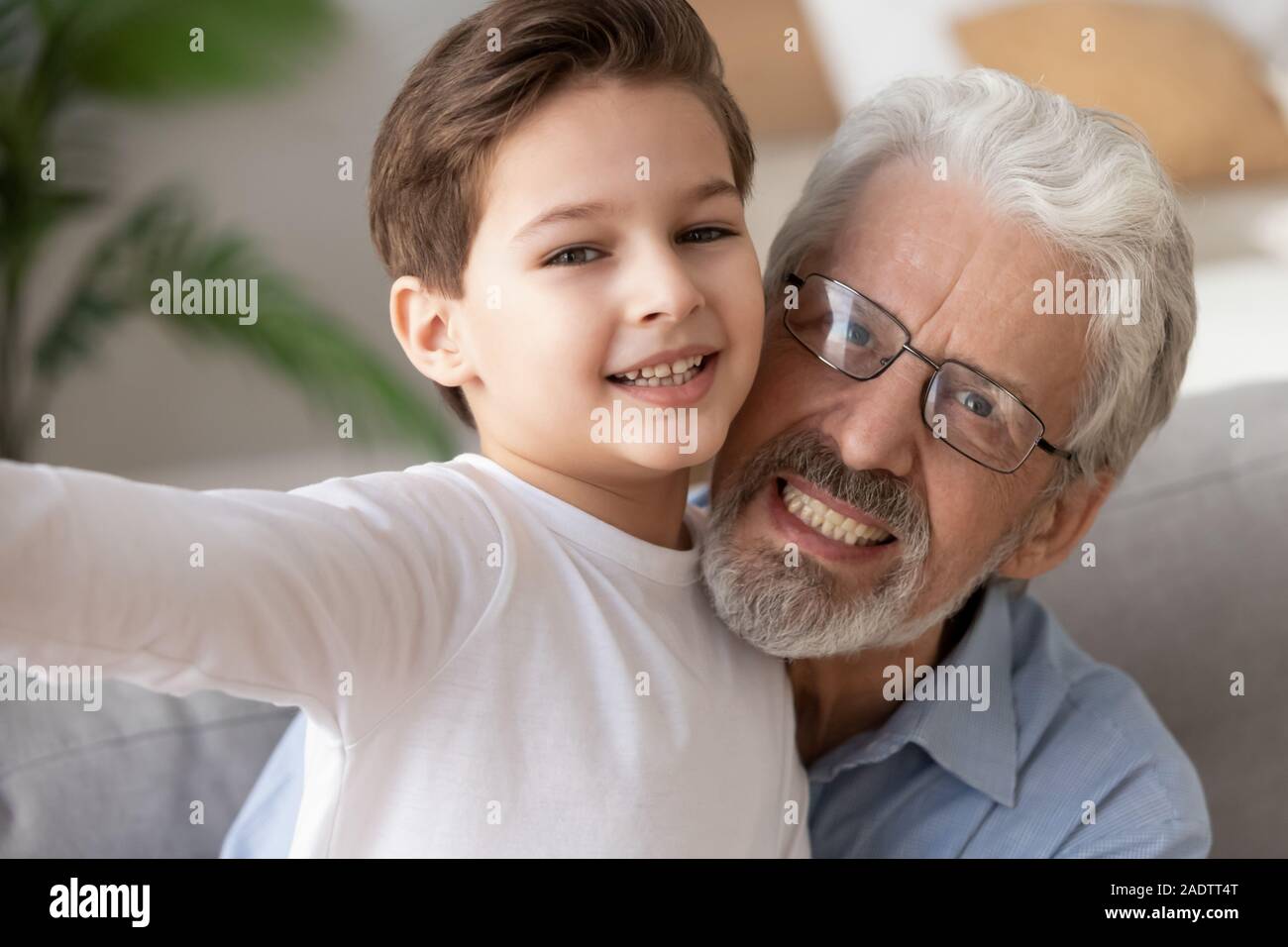 Portrait elderly grandfather and grandson taking selfie together webcam view Stock Photo