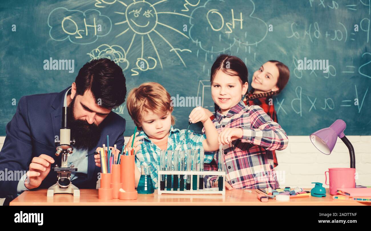 happy children teacher. experimenting with chemicals or microscope at laboratory. biology education. Microscope. back to school. Biology school laboratory equipment. Taking closer look at bacteria. Stock Photo