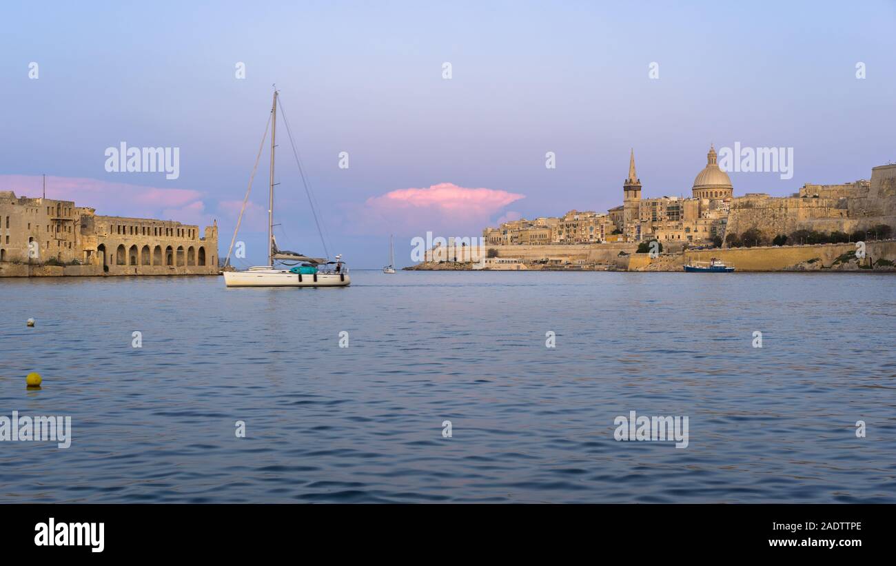 Malta. Valletta skyline at sunset with Basilica and Lazzaretto of Manoel Island, viewed from Ta Xbiex Stock Photo