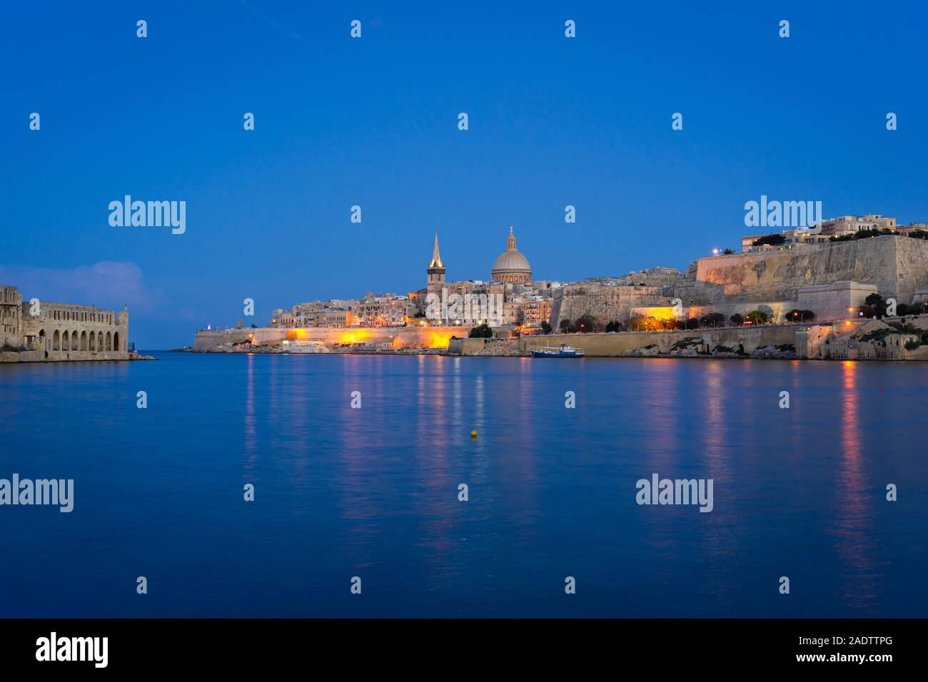 Malta. Valletta skyline at sunset with Basilica and Lazzaretto of Manoel Island, viewed from Ta Xbiex Stock Photo