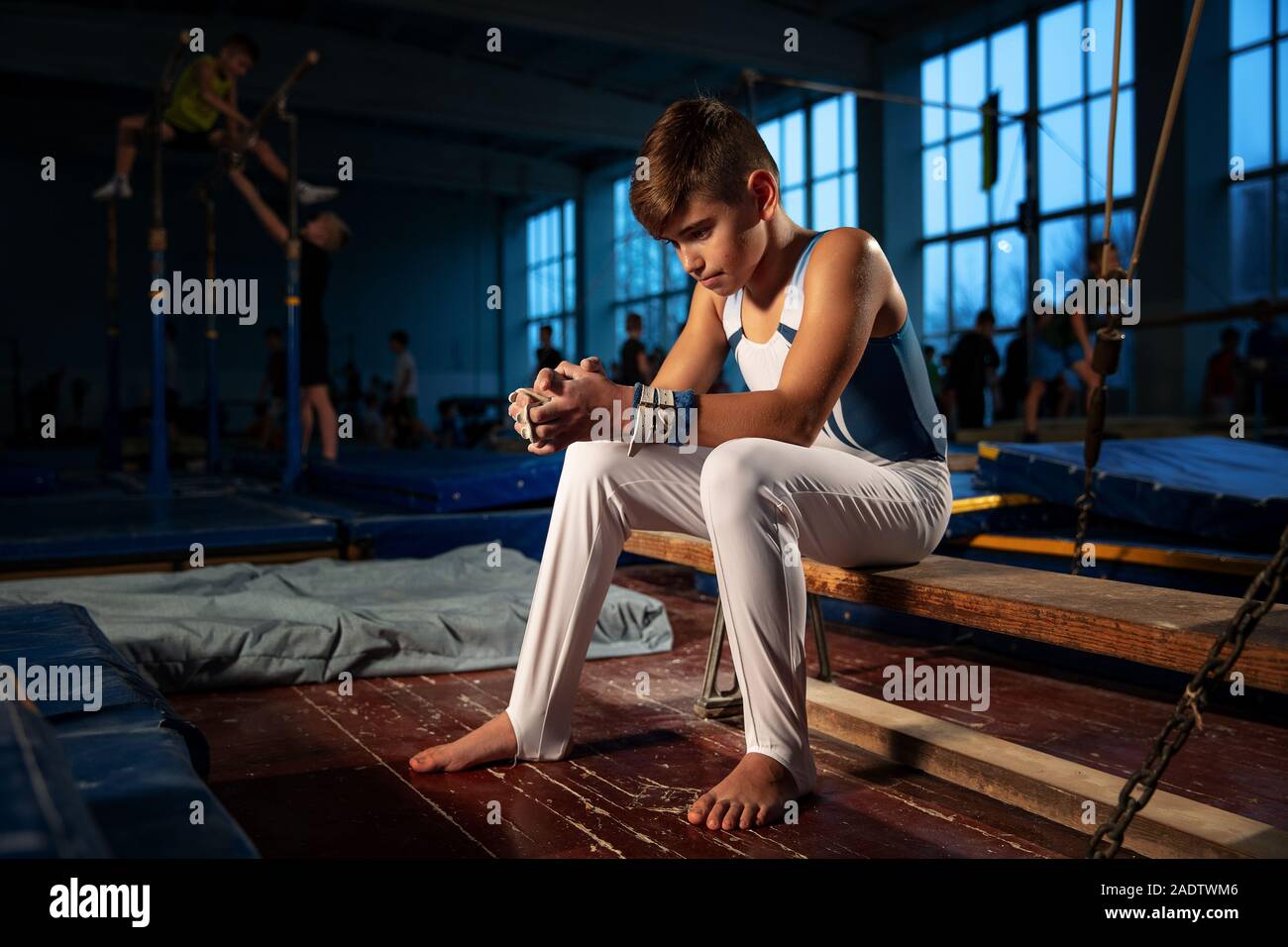 Little male gymnast training in gym, flexible and active. Caucasian fit