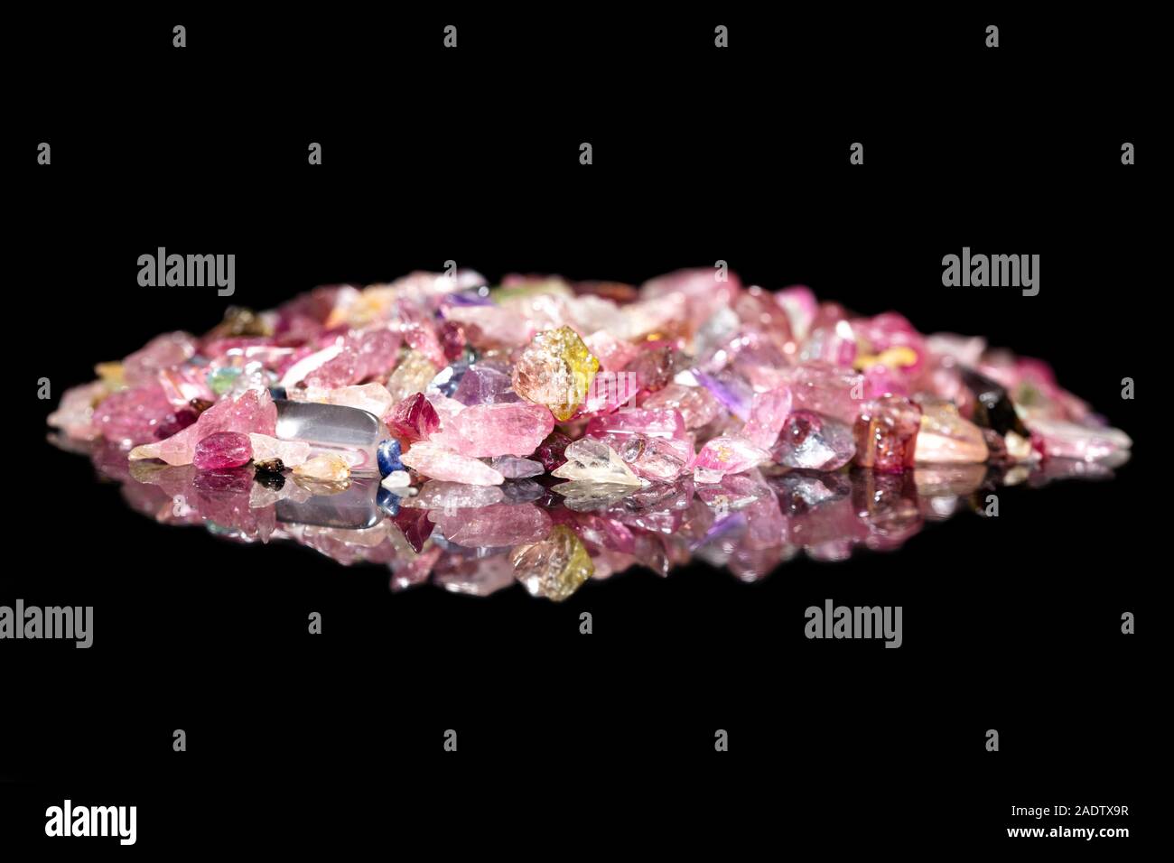 Many colorful Tourmaline splinter in front of black background with reflections and copyspace Stock Photo