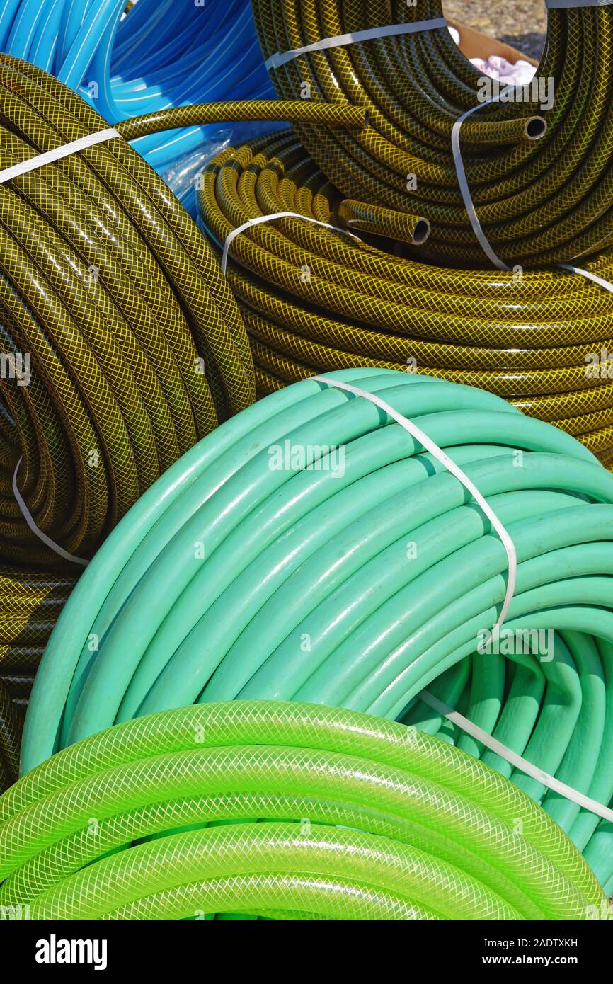 Many new green garden hoses in coils Stock Photo Alamy