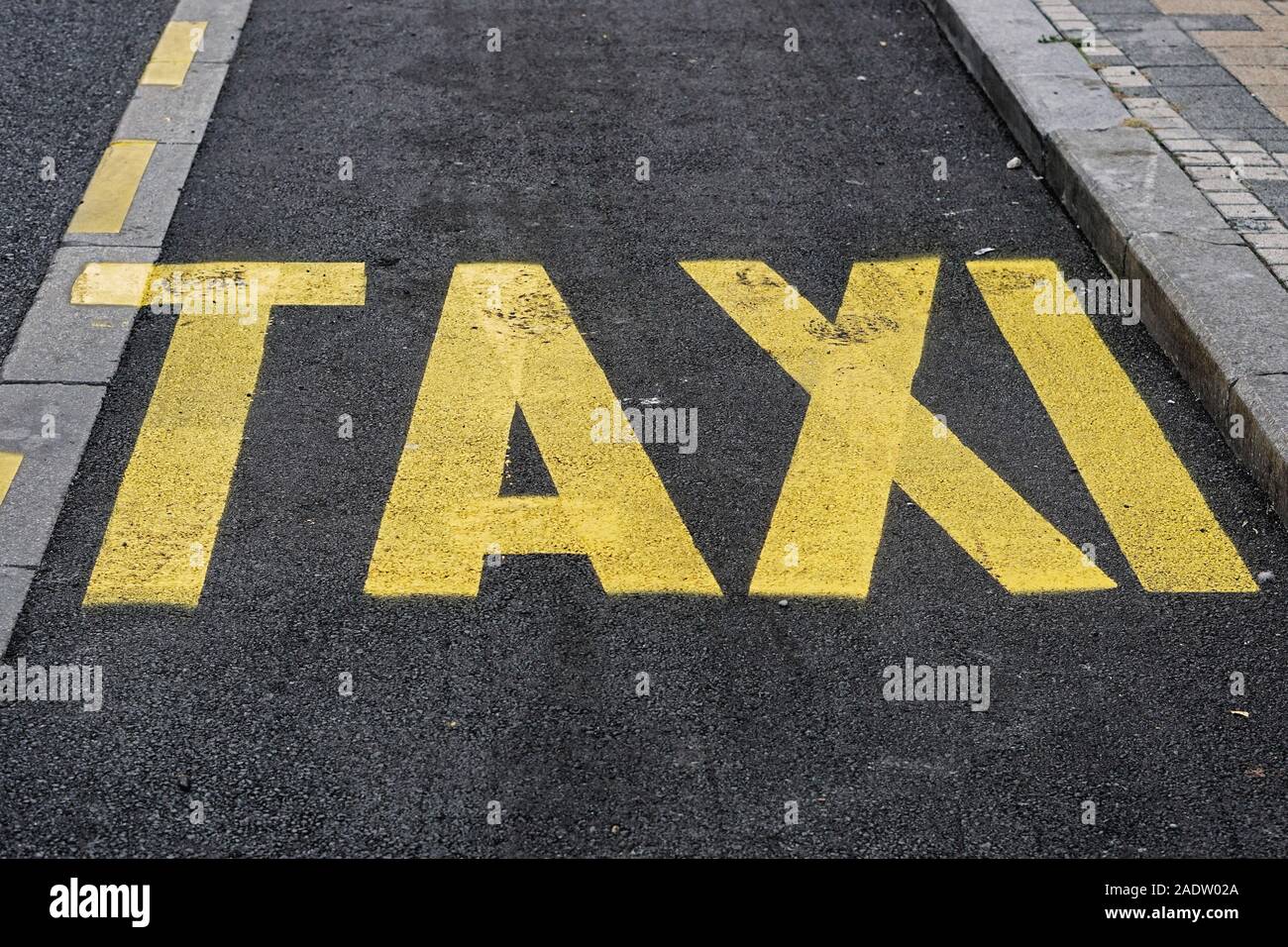 Yellow taxi sign paint at new black tarmac Stock Photo Alamy