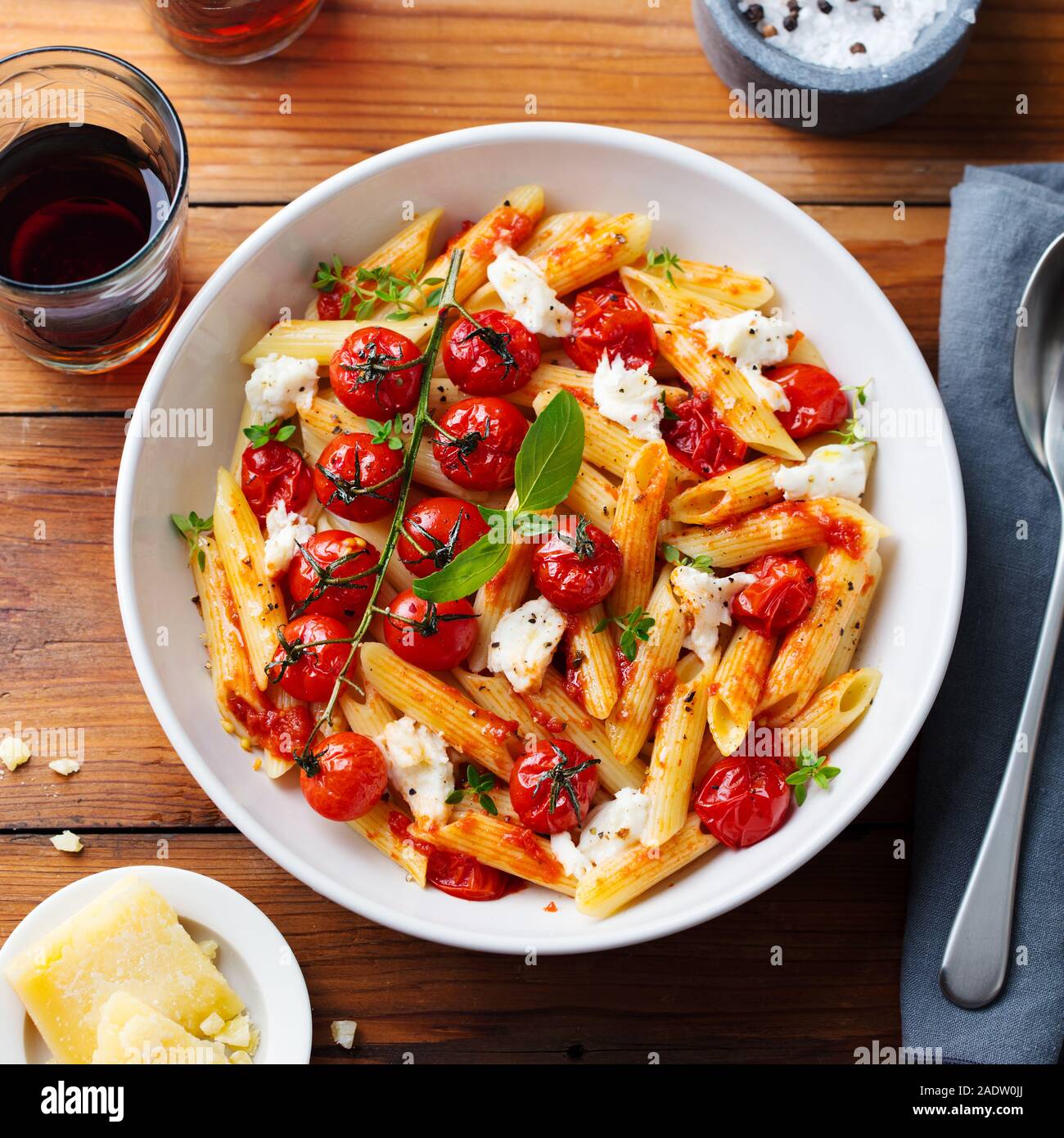 Pasta penne with roasted tomato, sauce, mozzarella cheese with glass red  wine. Wooden background. Top view Stock Photo - Alamy