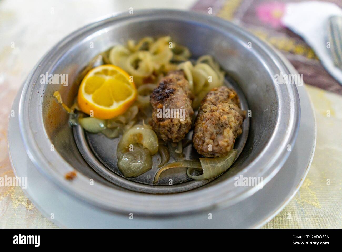 Traditional Mouthwatering Central Asian Tajik Kebap with Lemon Dish in a Metallic Bowl Stock Photo