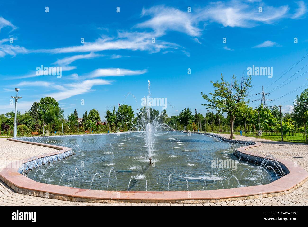 Dushanbe Youth Park Picturesque View of Pond with Fountains on a Sunny Blue Sky Day Stock Photo