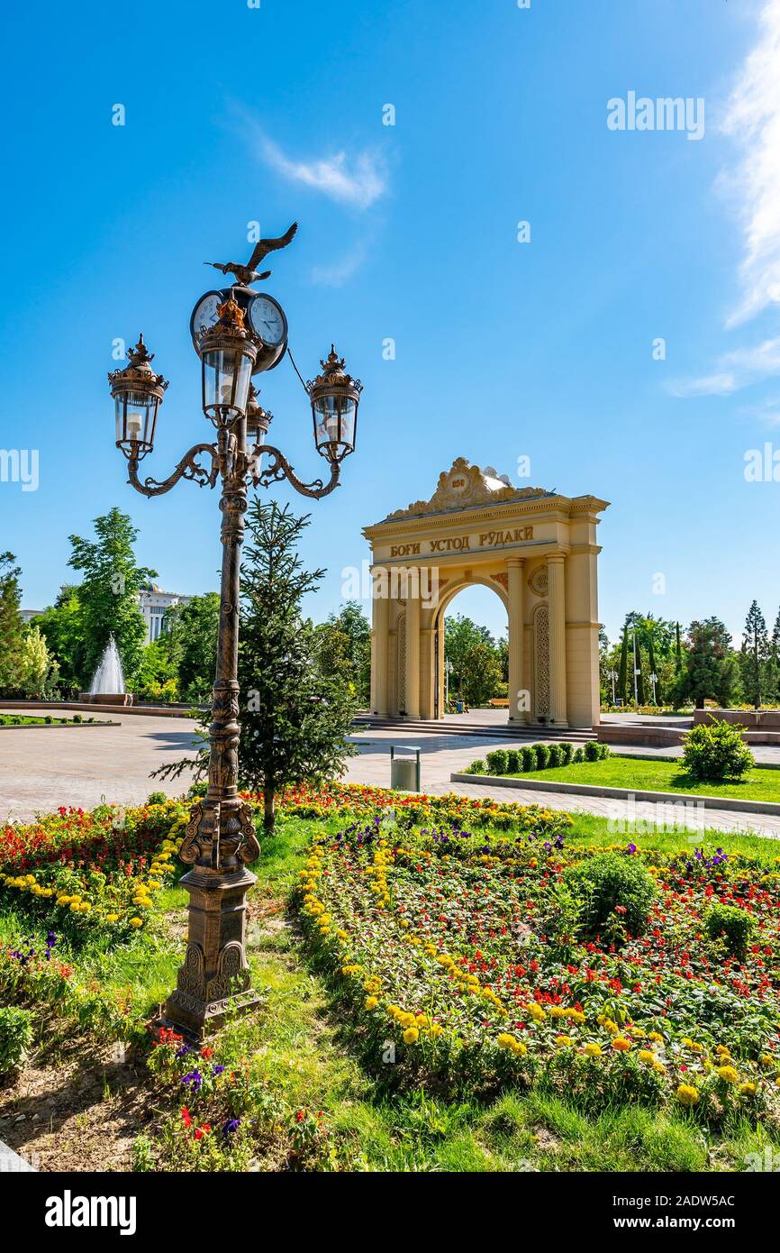Dushanbe Abu Abdullah Rudaki Park Picturesque View Arch of Triumph Entrance Gate with Flowers and Street Lights on a Cloudy Rainy Day Stock Photo