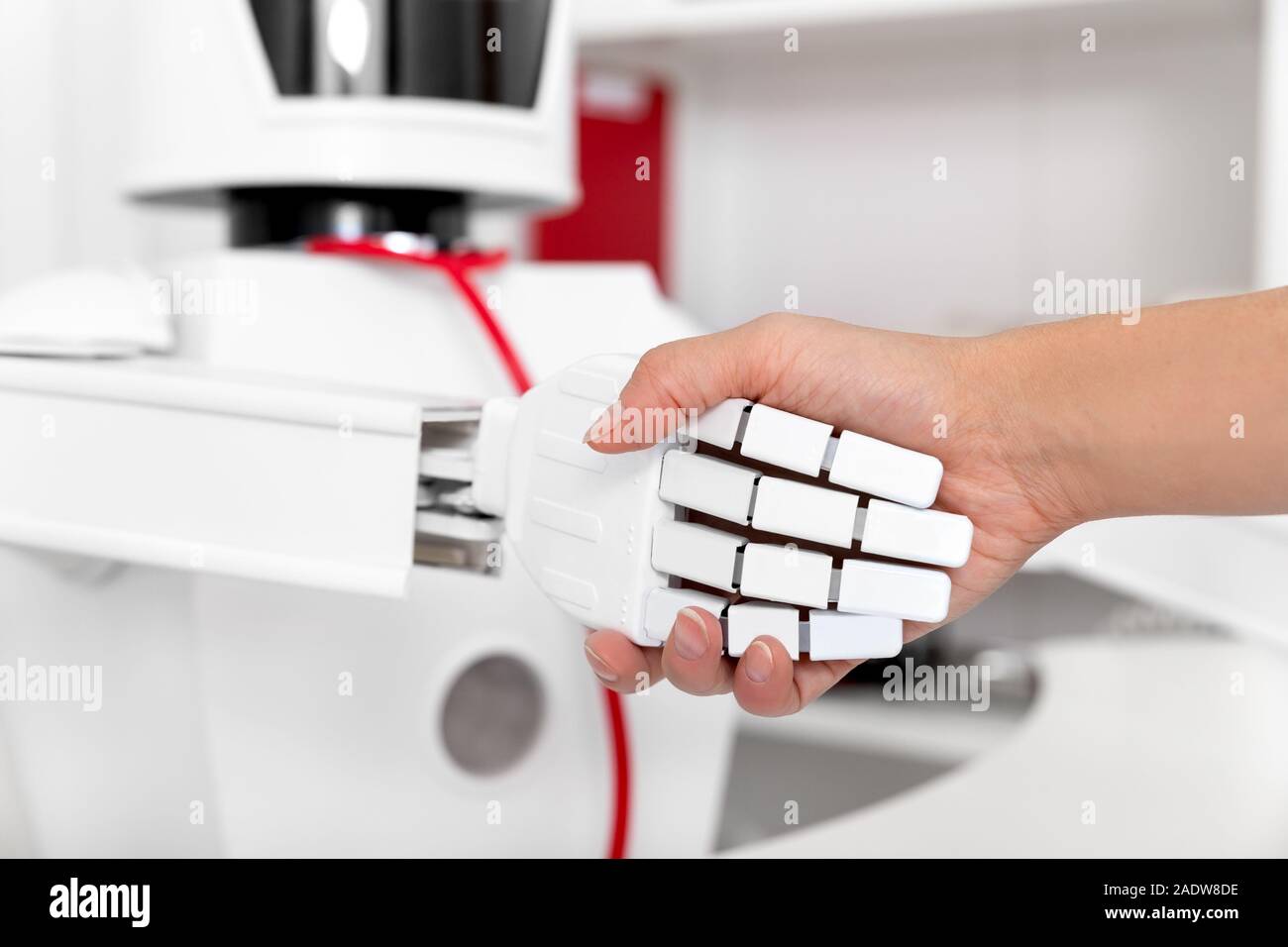 handshake between a female patient and a autonomous medicine robot in his office or surgery Stock Photo
