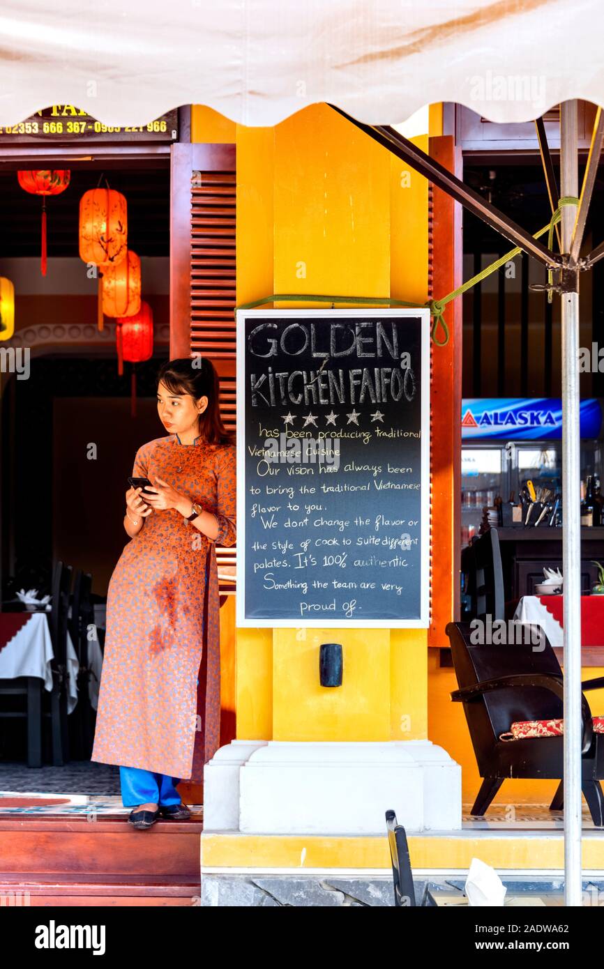 Lady standing outside Golden Kitchen restaurant Hoi An Vietnam Stock Photo