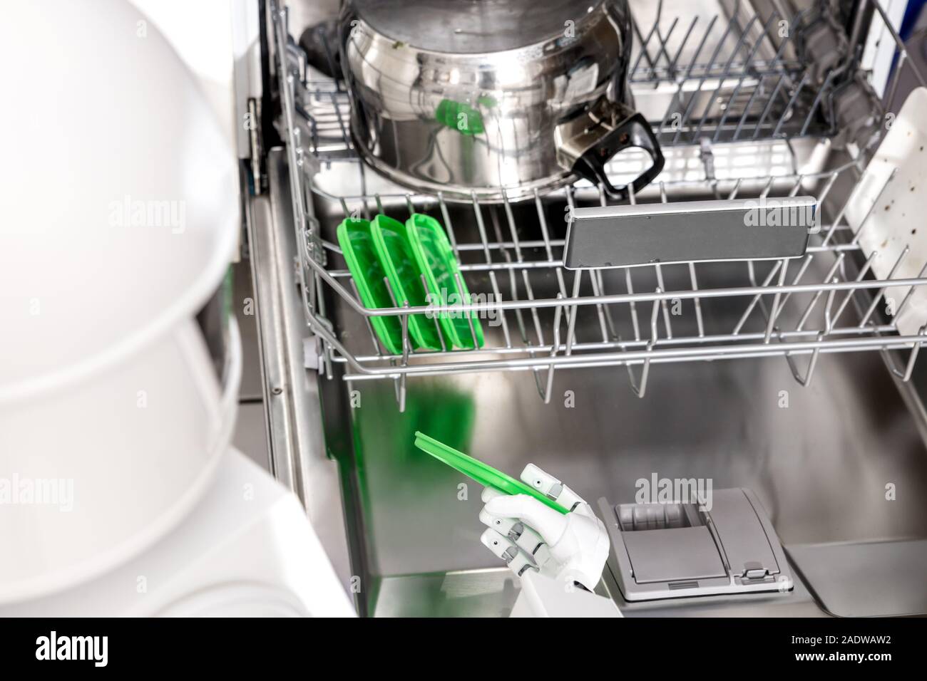 service autonomous household robot is putting dish in the dishwasher