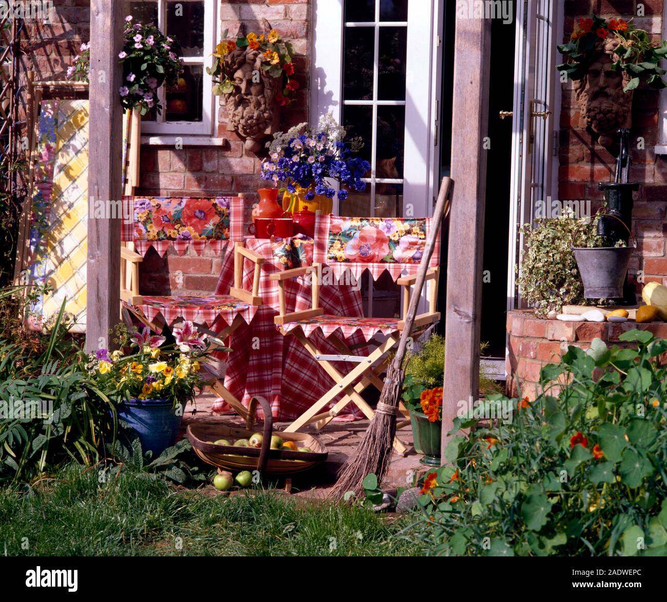 Colourful checked and floral fabric slings on renovated director's chairs on patio Stock Photo