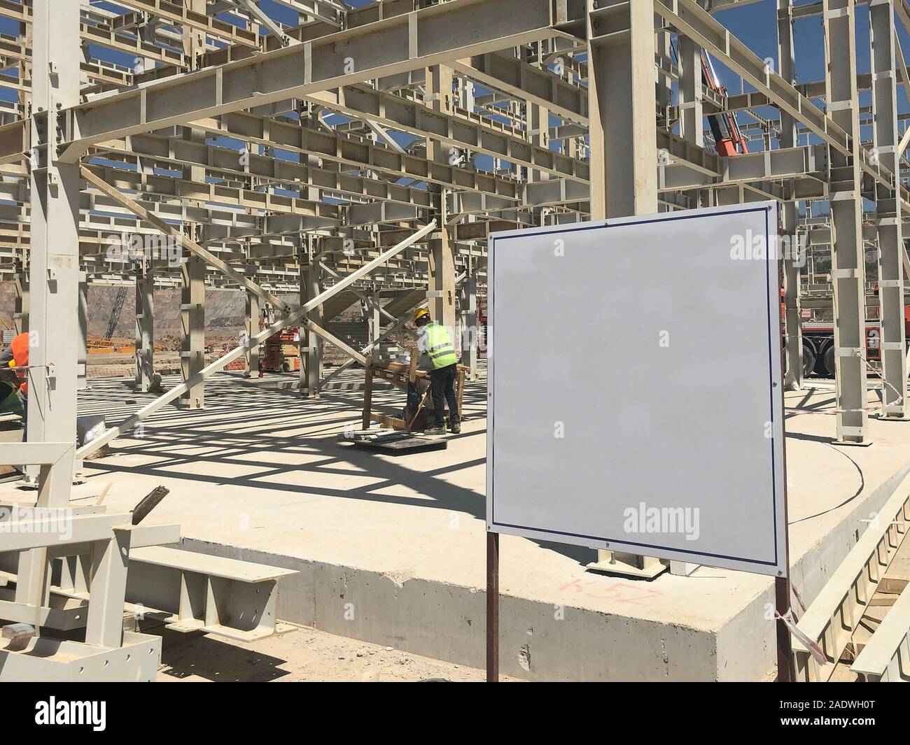 Object under construction stand at the construction site. Blank display board against prefabricated multi-storey building at the background Stock Photo