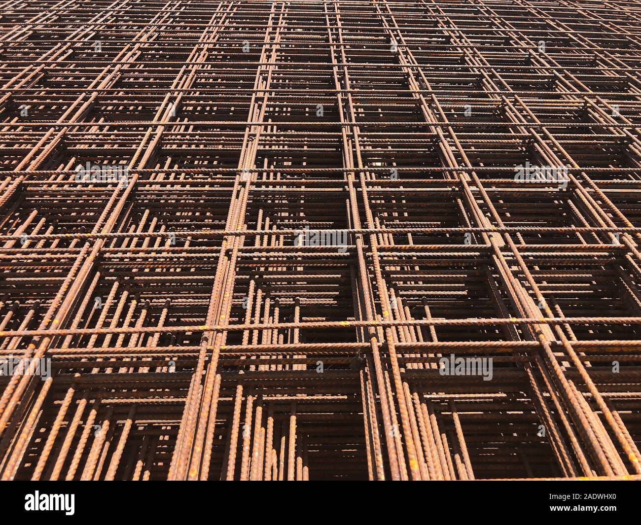 Piled iron reinforcement workpieces. Metal mesh for reinforcement. Iron rusty rectangular structure. Stock Photo