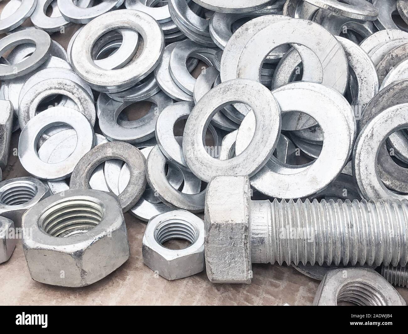 Steel nuts, bolts and washers piled in the box. Fastening construction equipment. Fixing