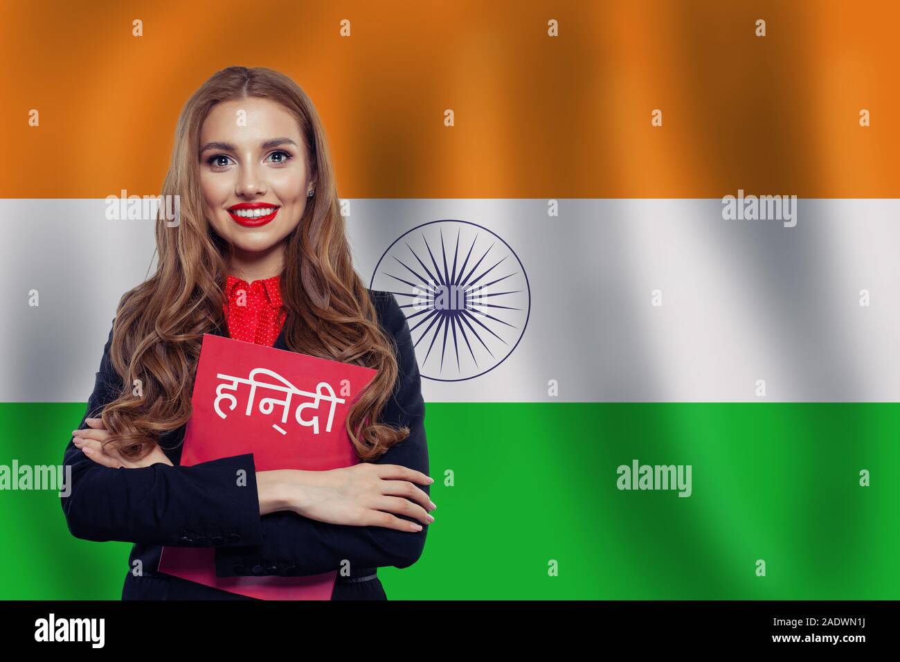 Happy girl student against the India flag background. Book with inscription Hindi on indian language Stock Photo