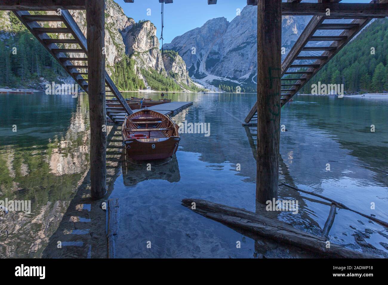Rowing boats moored on the jetty in a lake with dolomitic mountain ...