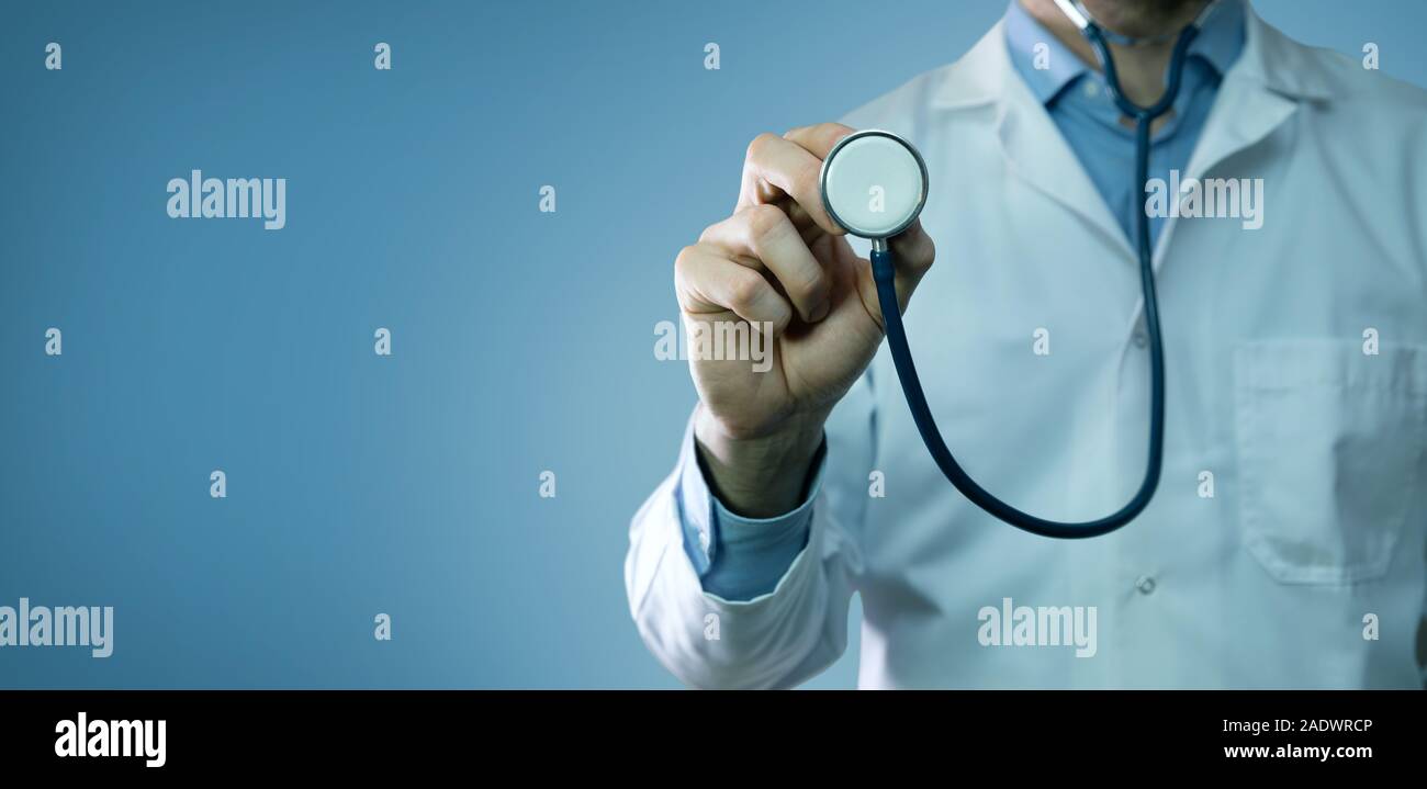 healthcare and medicine - doctor in white coat holding stethoscope on blue background. copy space Stock Photo