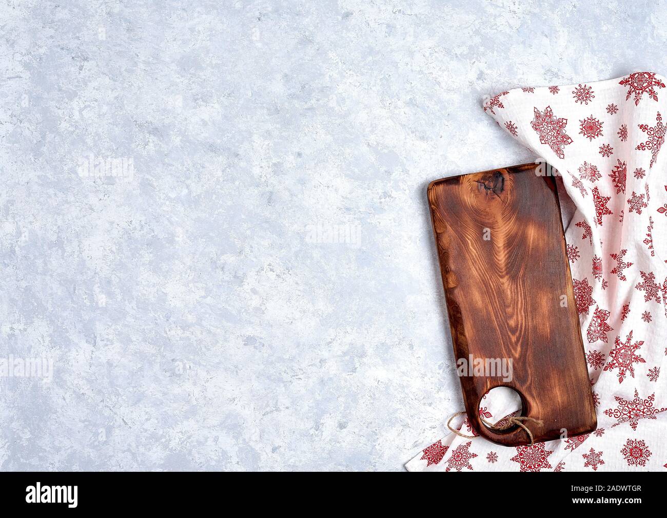 Empty kitchen cutting board with red christmas tablecloth. Stock Photo