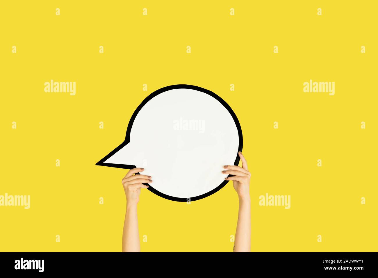 Hands holding the sign of comment on yellow studio background. Negative ...