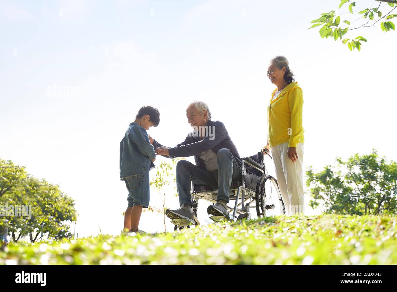 asian grandfather grandmother and grandson having fun outdoors in park Stock Photo