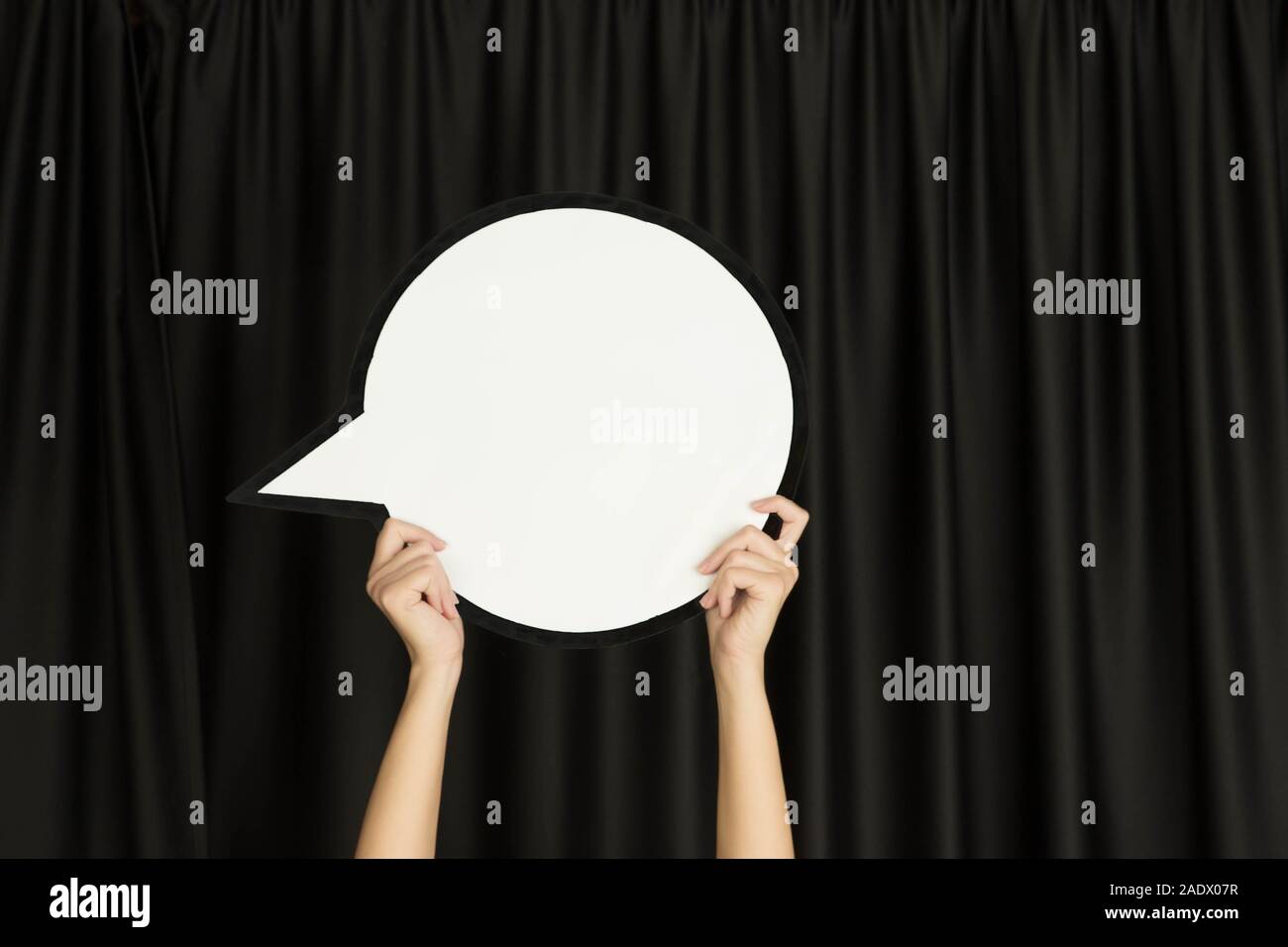 Hands holding the sign of comment on black studio background. Negative ...
