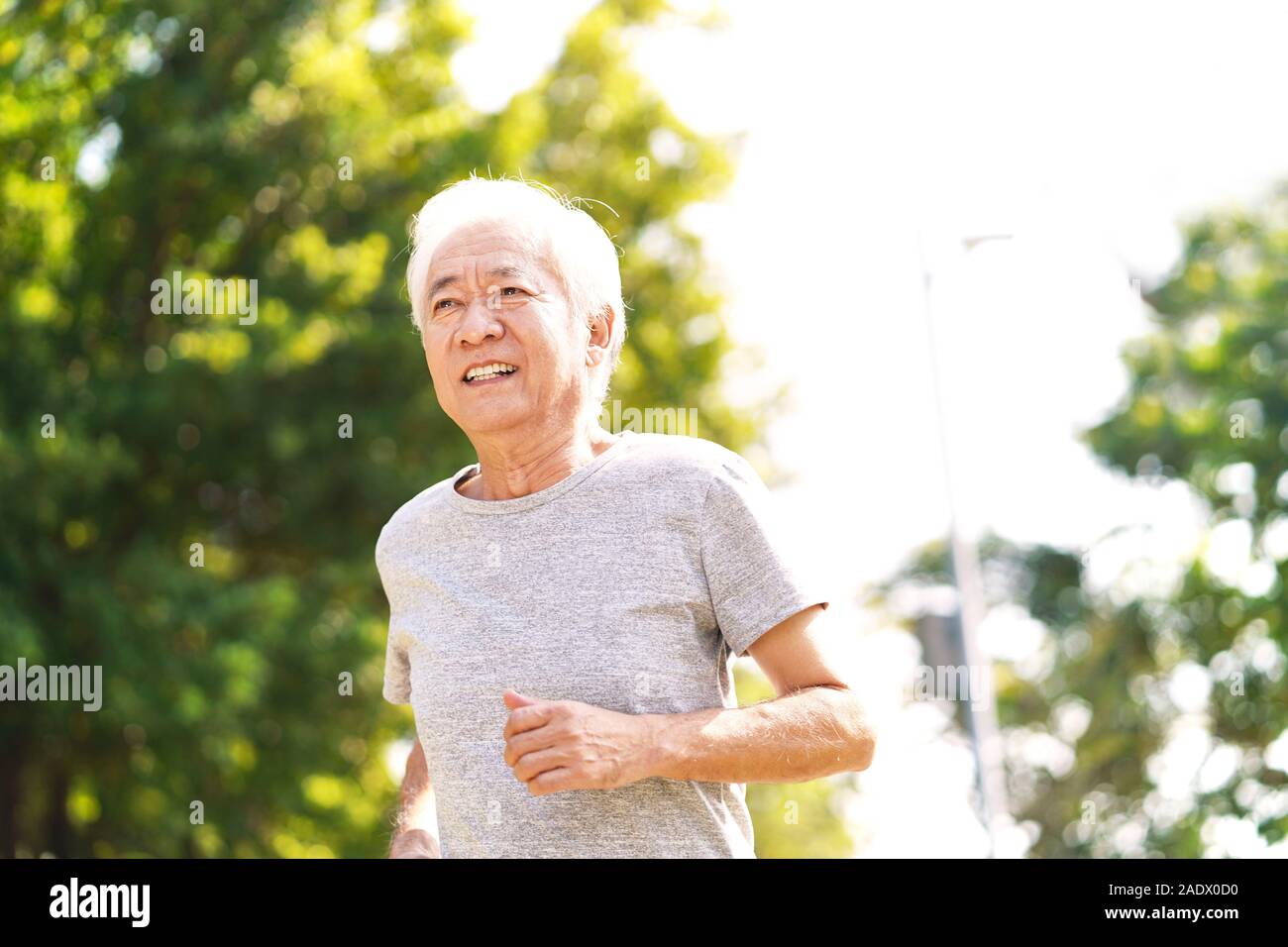 healthy senior asian man running exercising outdoors Stock Photo