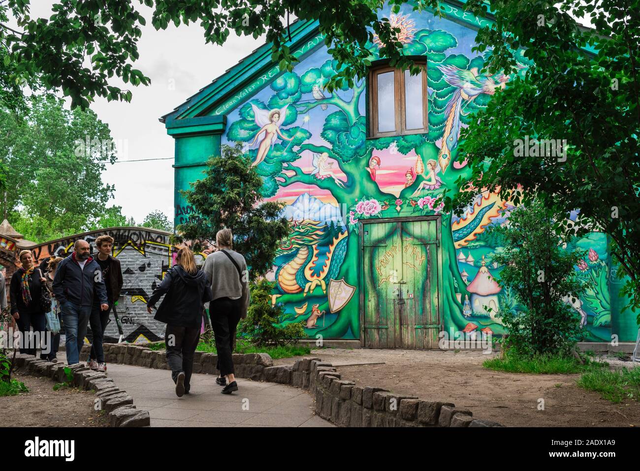 Christiania Copenhagen, view of people passing a colorful illustrated house inside the alternative Freetown area of Christiania, Copenhagen, Denmark. Stock Photo