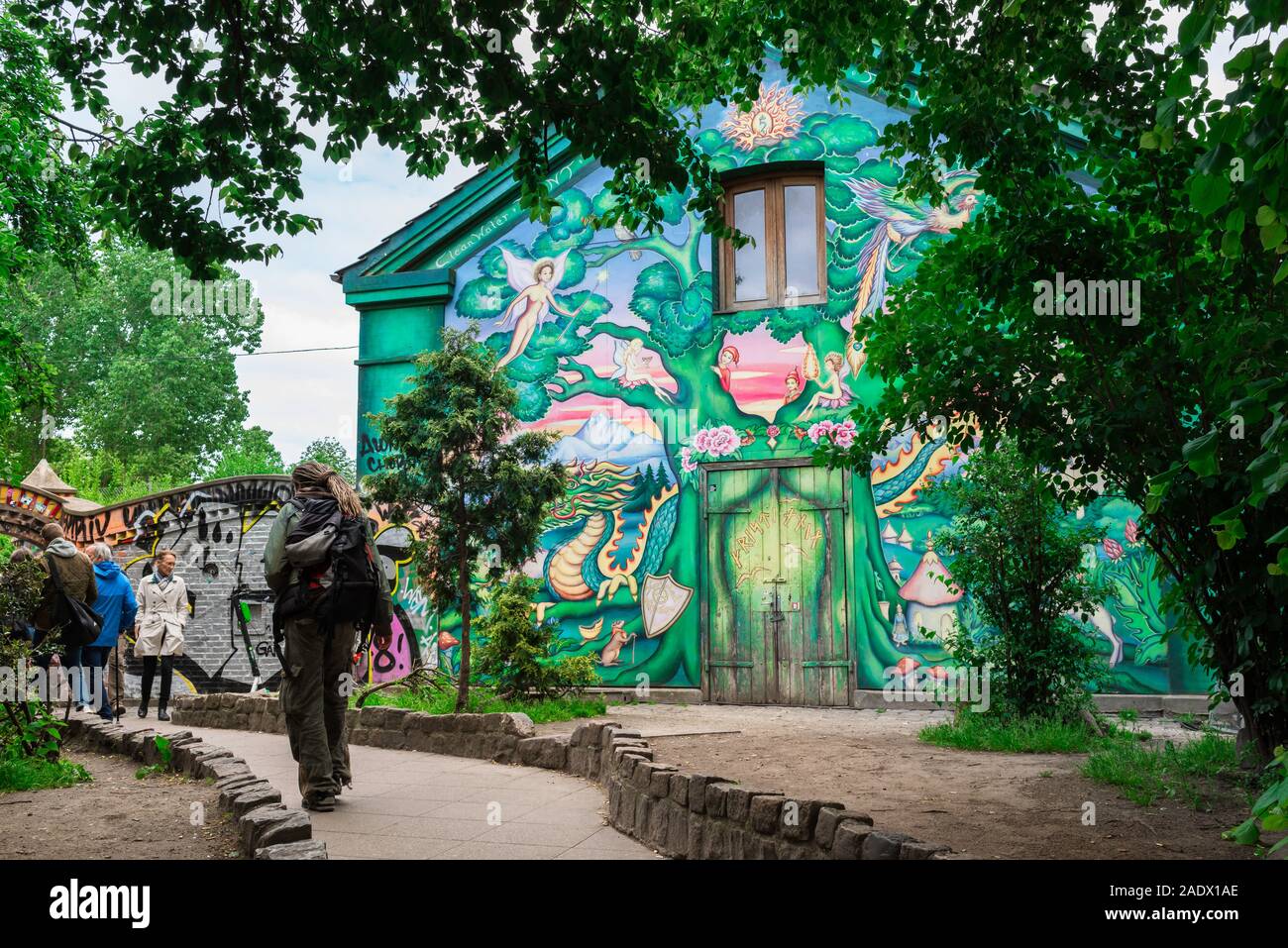 Alternative Denmark, rear view of a man walking past a colorful illustrated house inside the Freetown area of Christiania, Copenhagen, Denmark Stock Photo