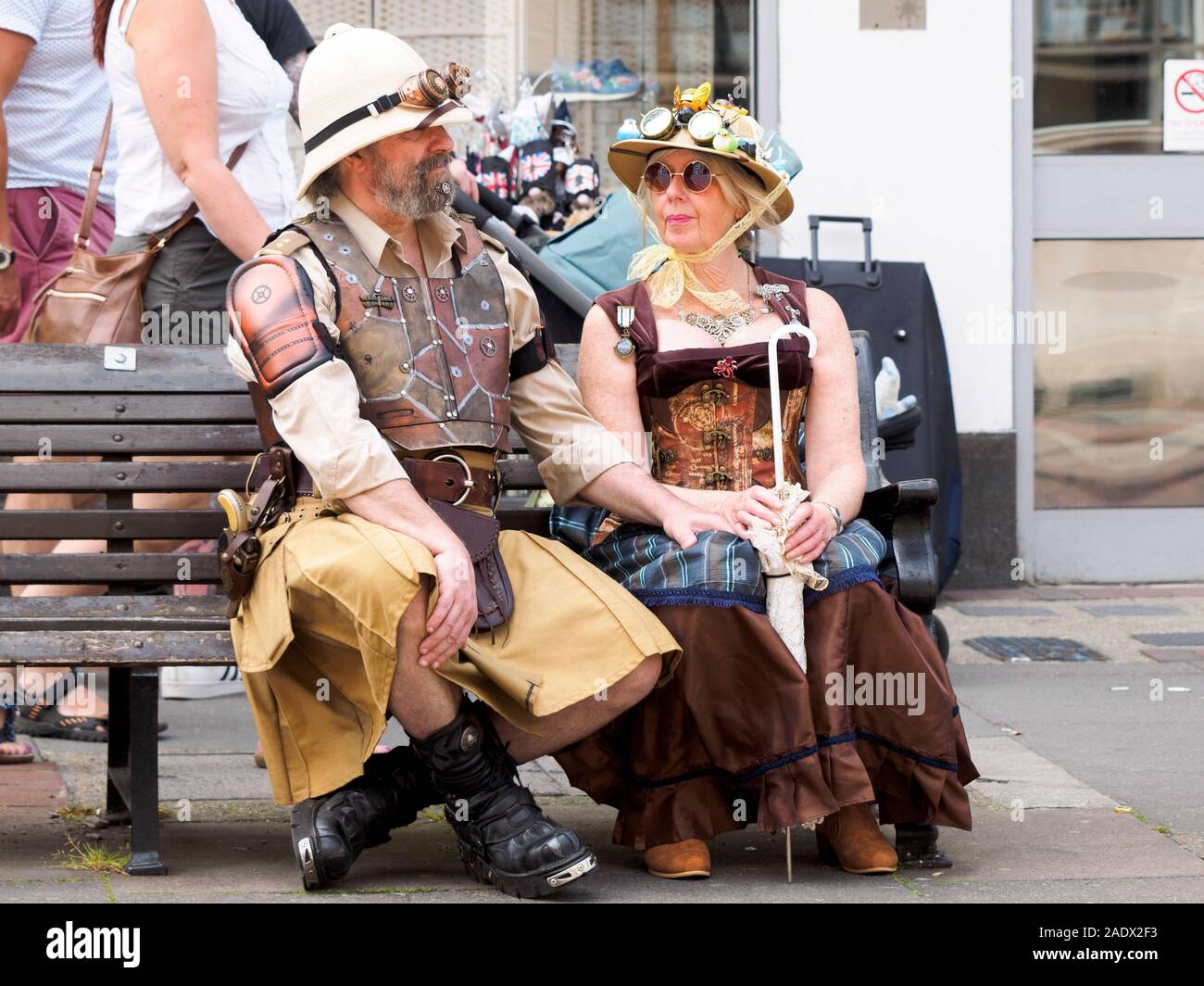 A steampunk couple sitting on a bench at the Summer Rochester Dickens Festival 2019. Stock Photo