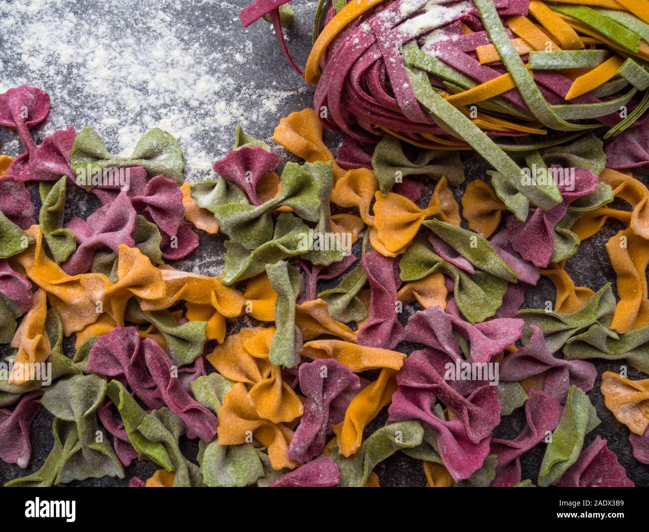 Variety of raw pasta types, farfalle bowtie, fettuccine or tagliatelle