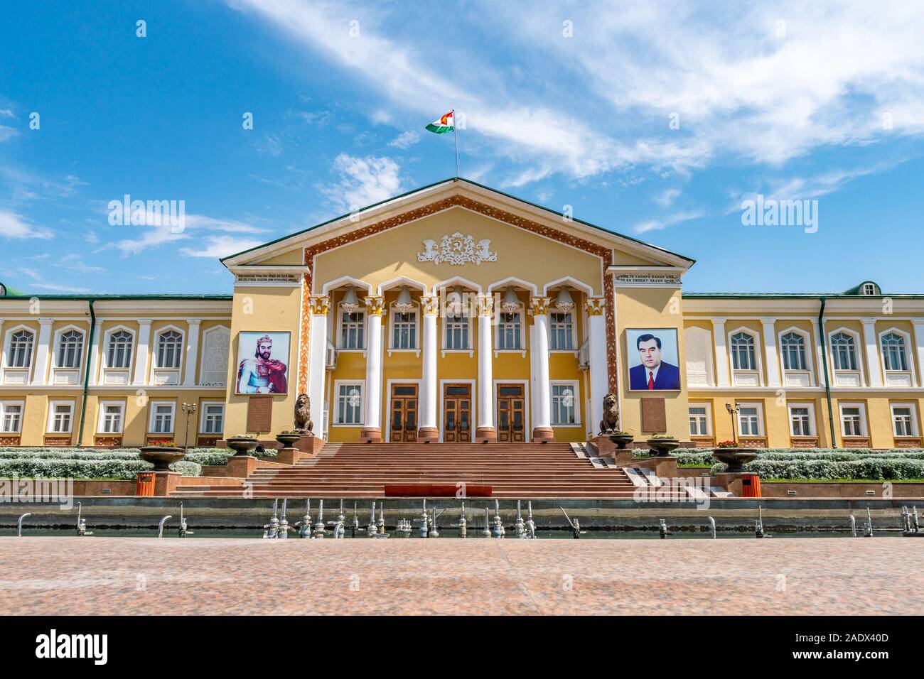 Khujand Arbob Cultural Palace View with Waving Tajikistan Flag and Portraits of Ismoil Somoni and President Emomali Rahmon on a Sunny Blue Sky Day Stock Photo
