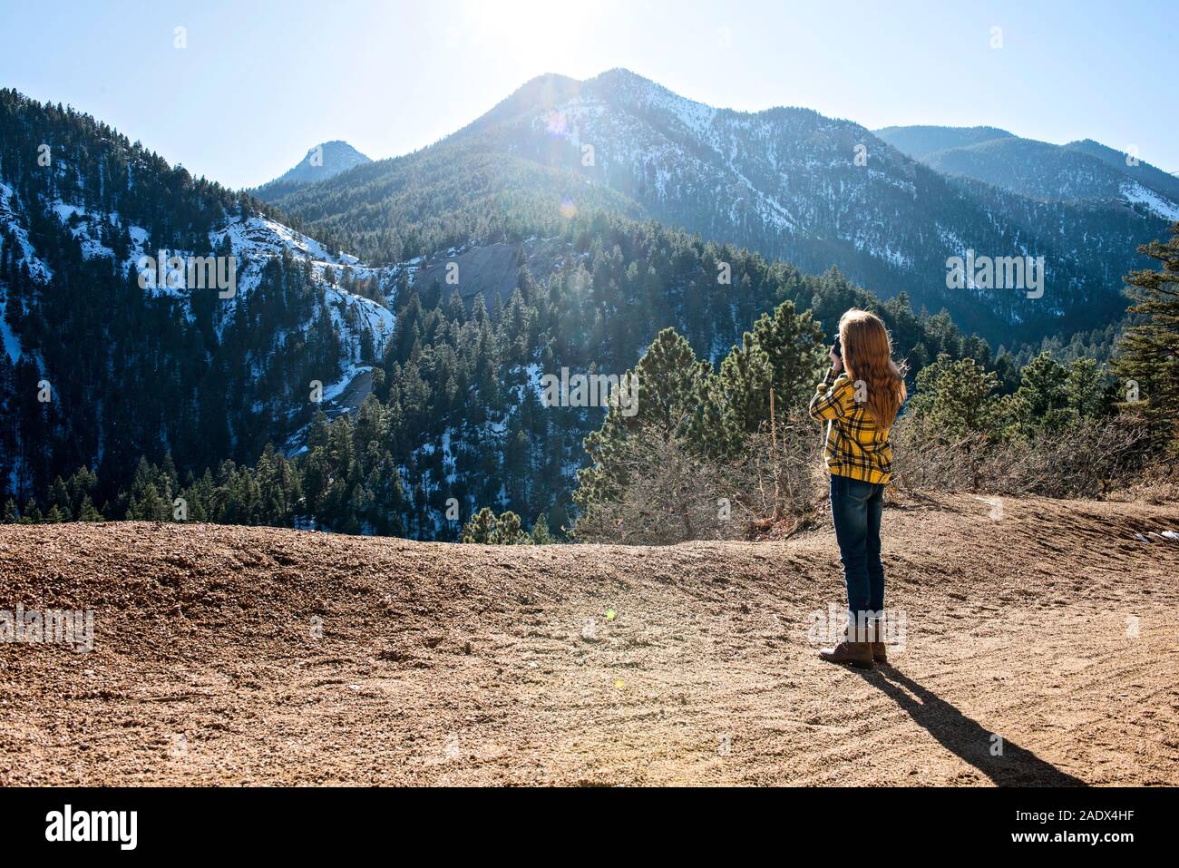 Young Girl Hiking in the Mountains Taking Pictures Stock Photo