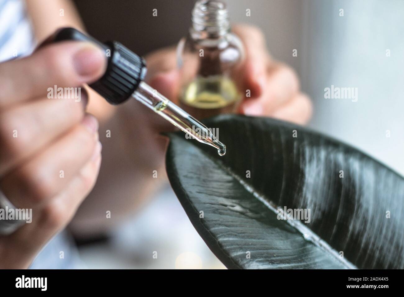 A drop of organic oil and green leave. Cosmetology health care Stock Photo