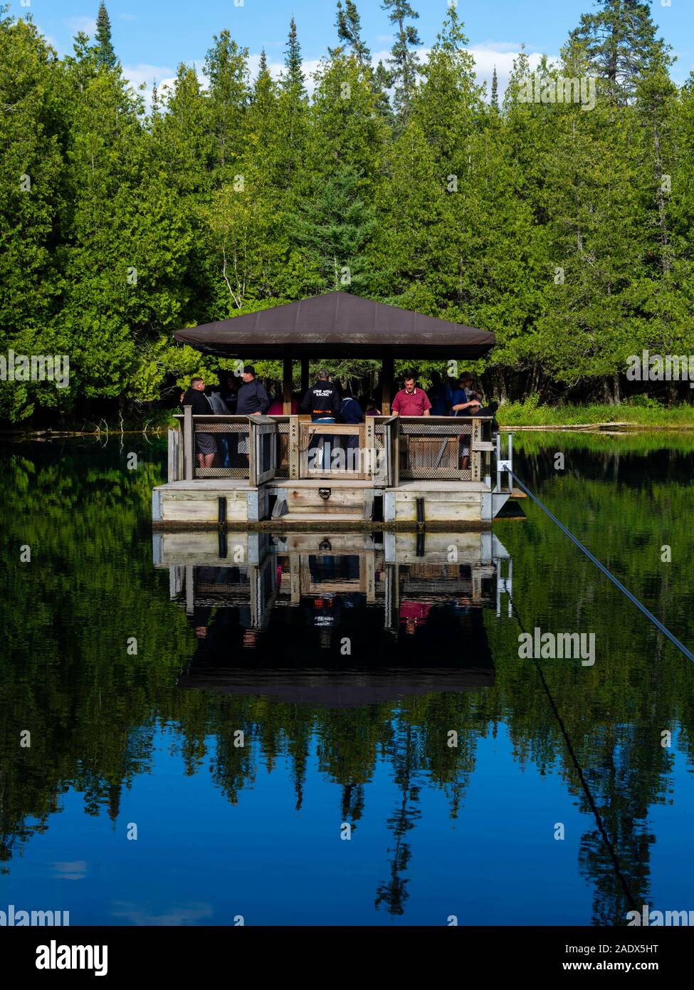 Tourists venture out on a barge to view trout in crystal clear water in