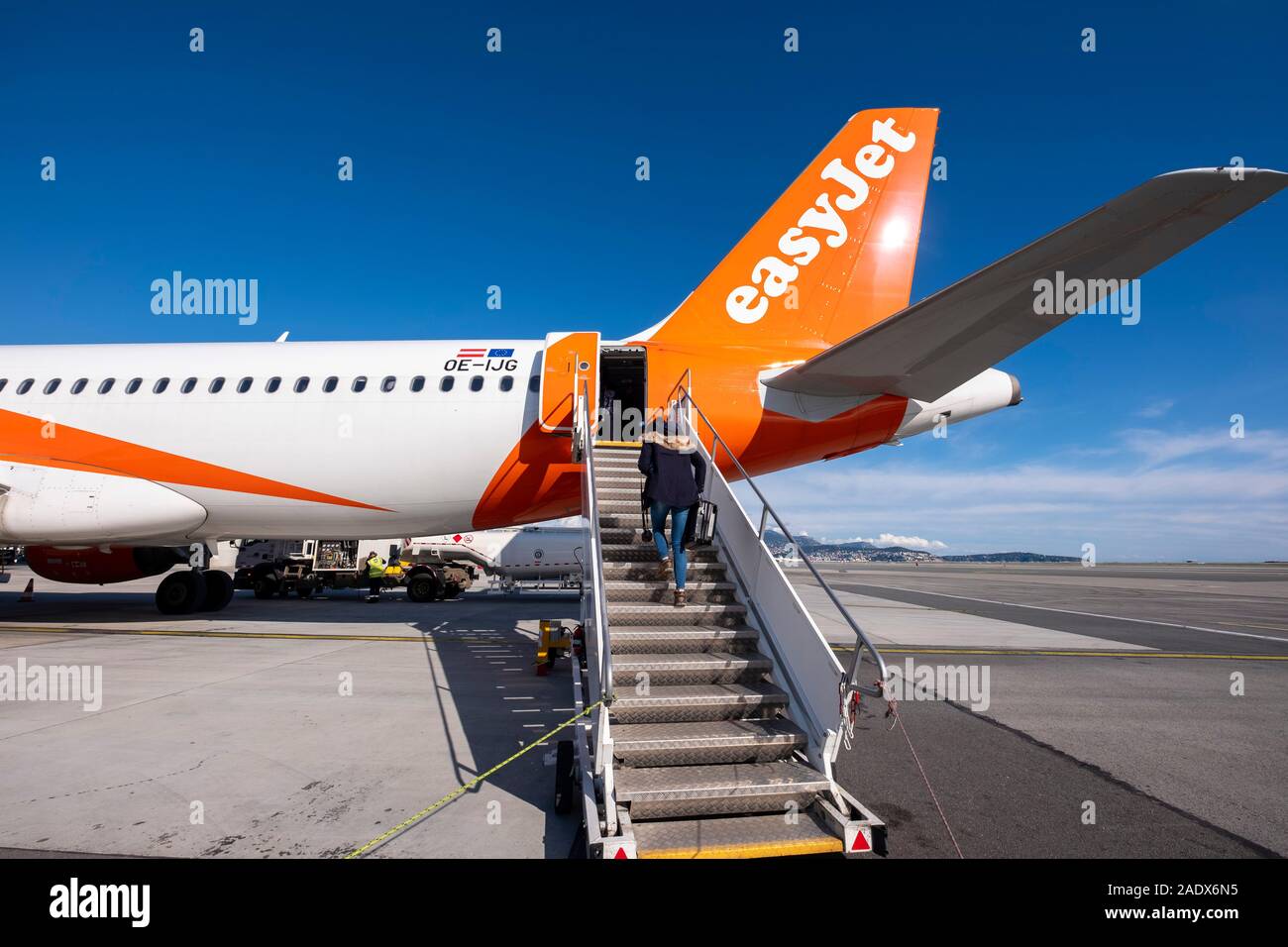 Woman boarding an easyJet airplane through the rear entrance door Stock Photo