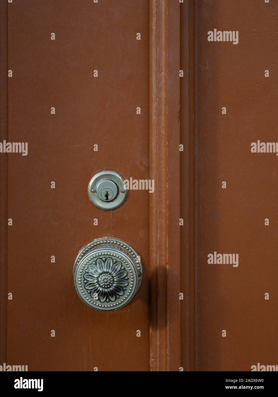 Door knob and keyhole on a brown wooden door Stock Photo