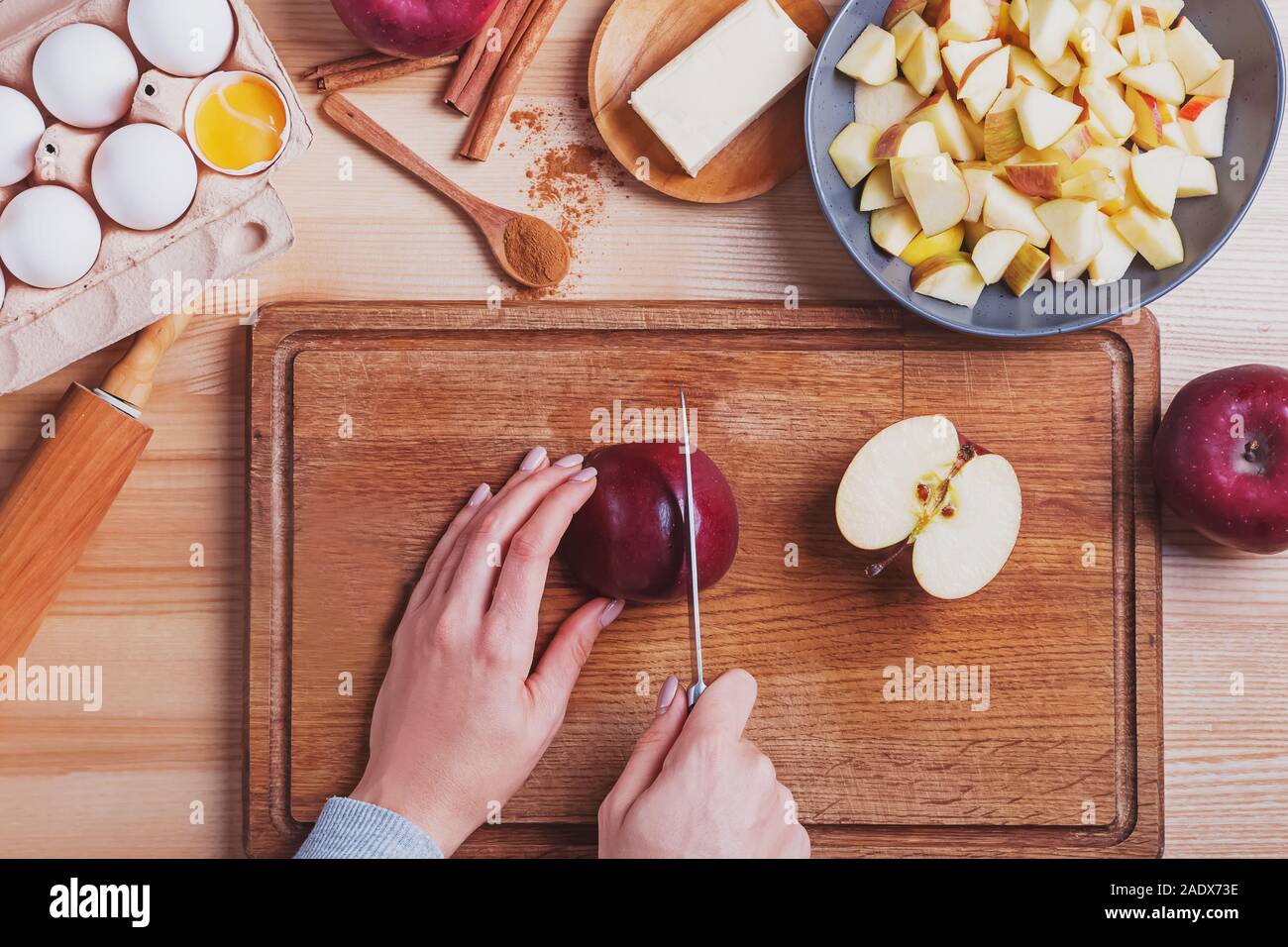 Woman's hands cutting red apple on the table Stock Photo