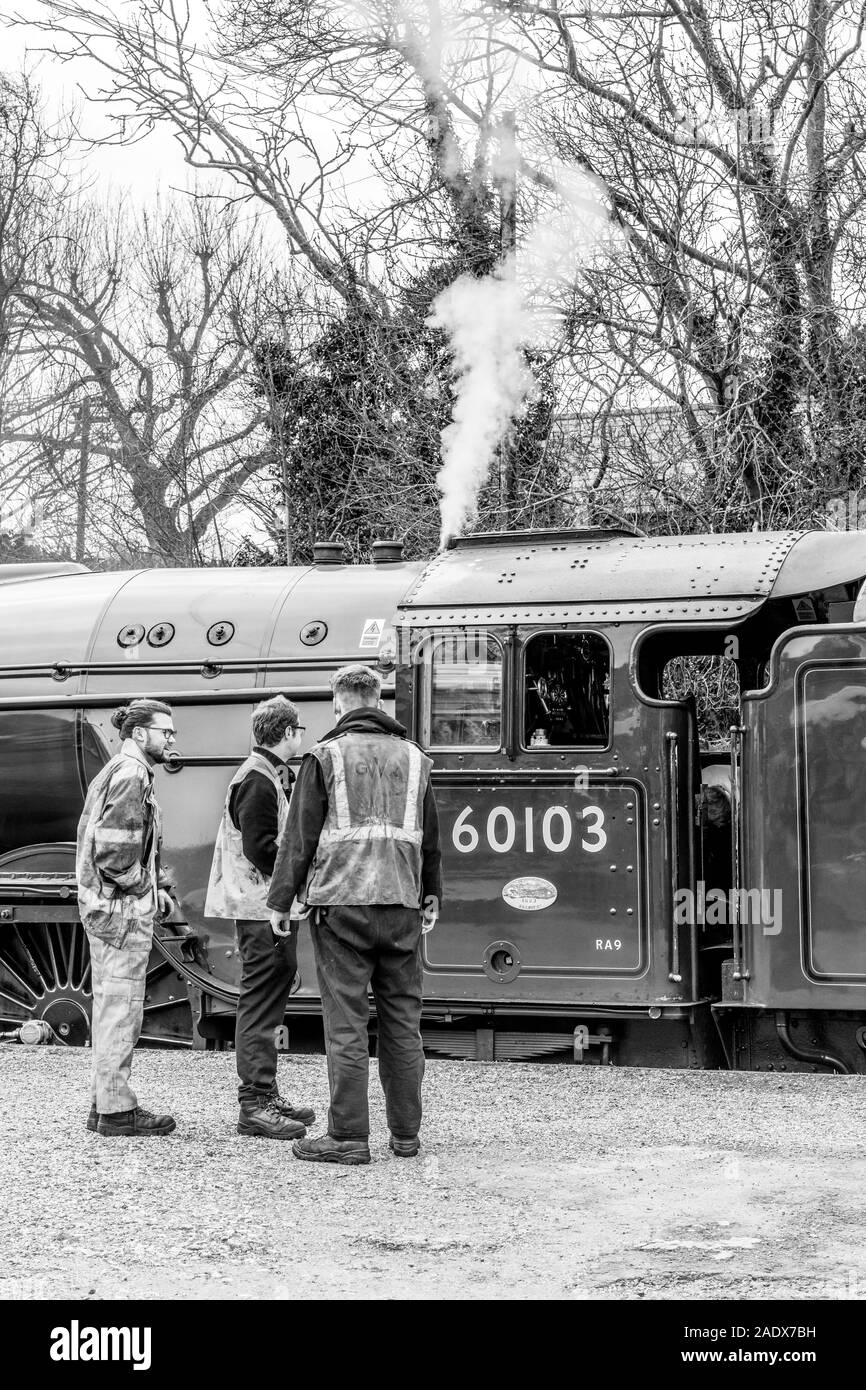 Staffs stand on the station service alongside to Flying Scotsman famous railway Stock Photo