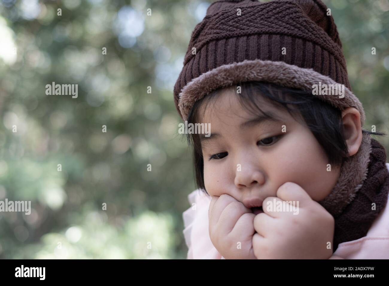 Portrait of a cute little girl in wool hat on blurred background Stock