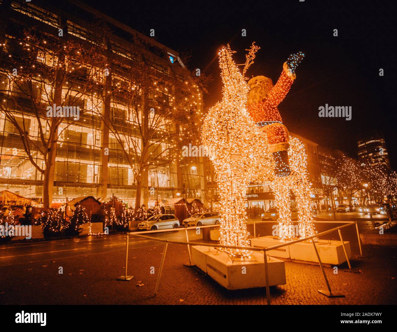 Leuchtender Weihnachtsmann aus Lichterketten reitet auf Rentier im Winter in Berlin Stock Photo