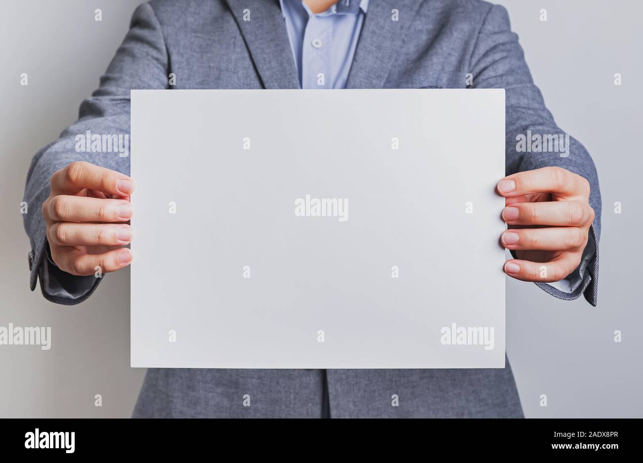 Man in suit holding a blank paper Stock Photo