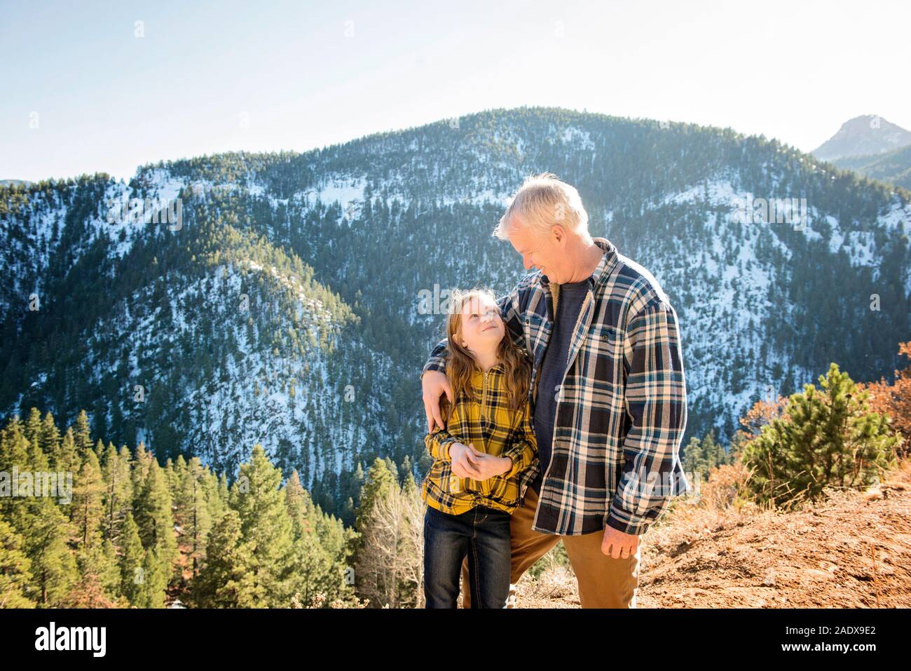Grandfather and Granddaughter Hiking in the Mountains Stock Photo