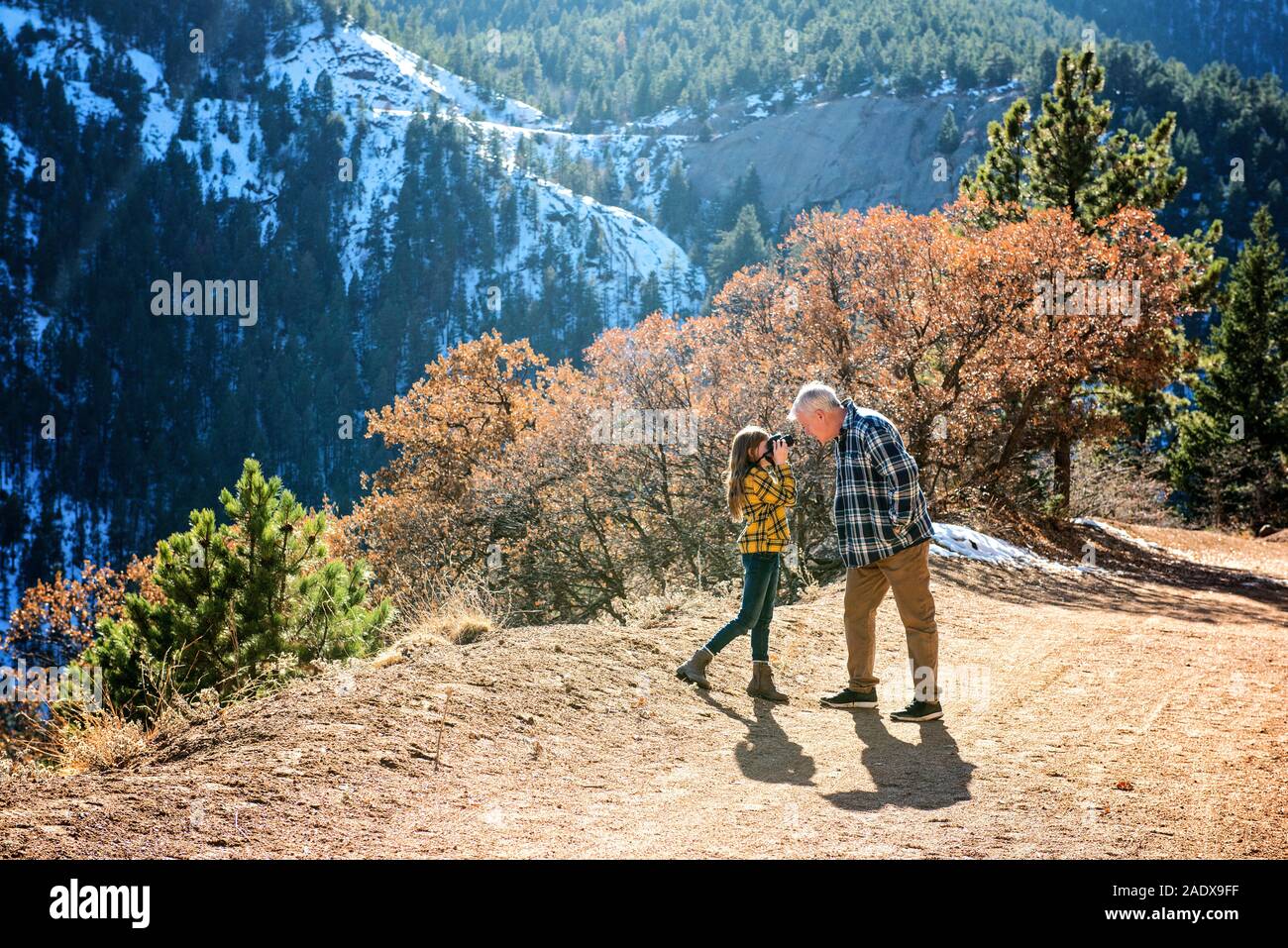 Grandfather and Granddaughter Hiking in the Mountains Taking Pictures Stock Photo