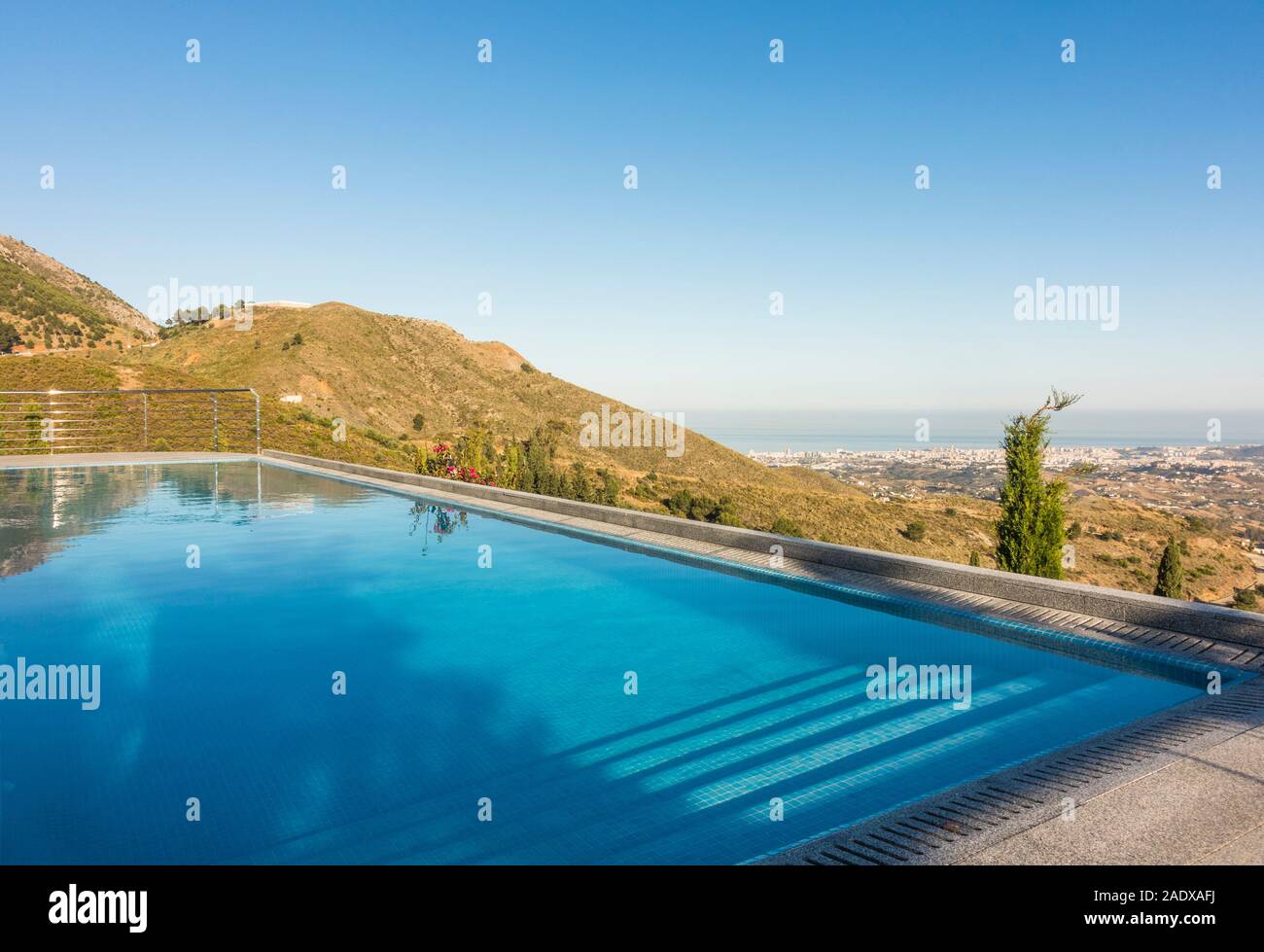 Infinity swimming pool with lounge chair and view to mediterranean ...