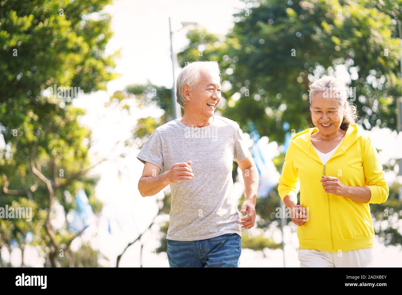 happy asian senior couple running exercising outdoors in park Stock ...