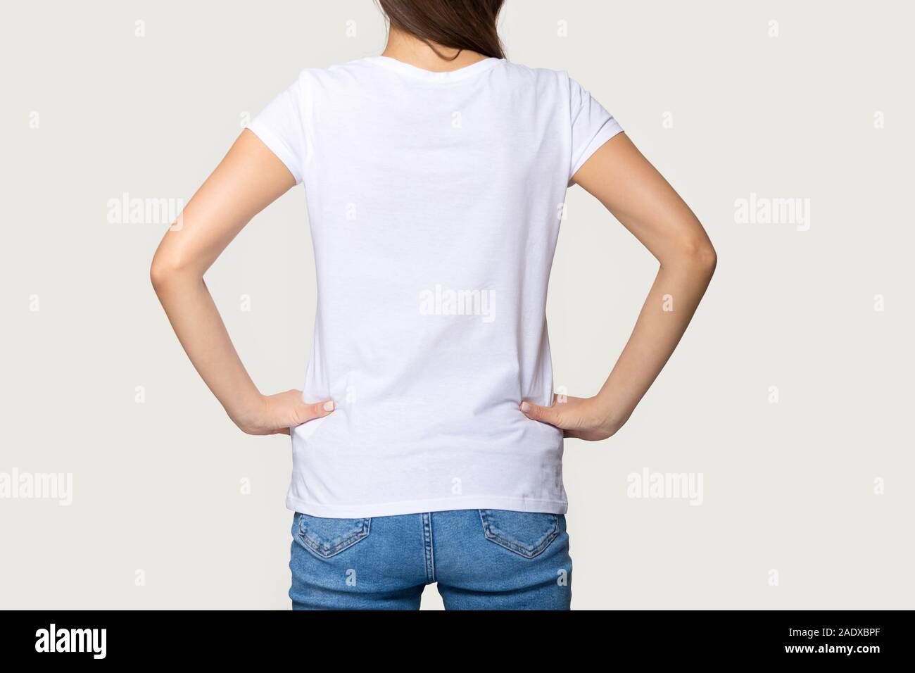 Millennial female wearing white t-shirt standing turning back to camera Stock Photo