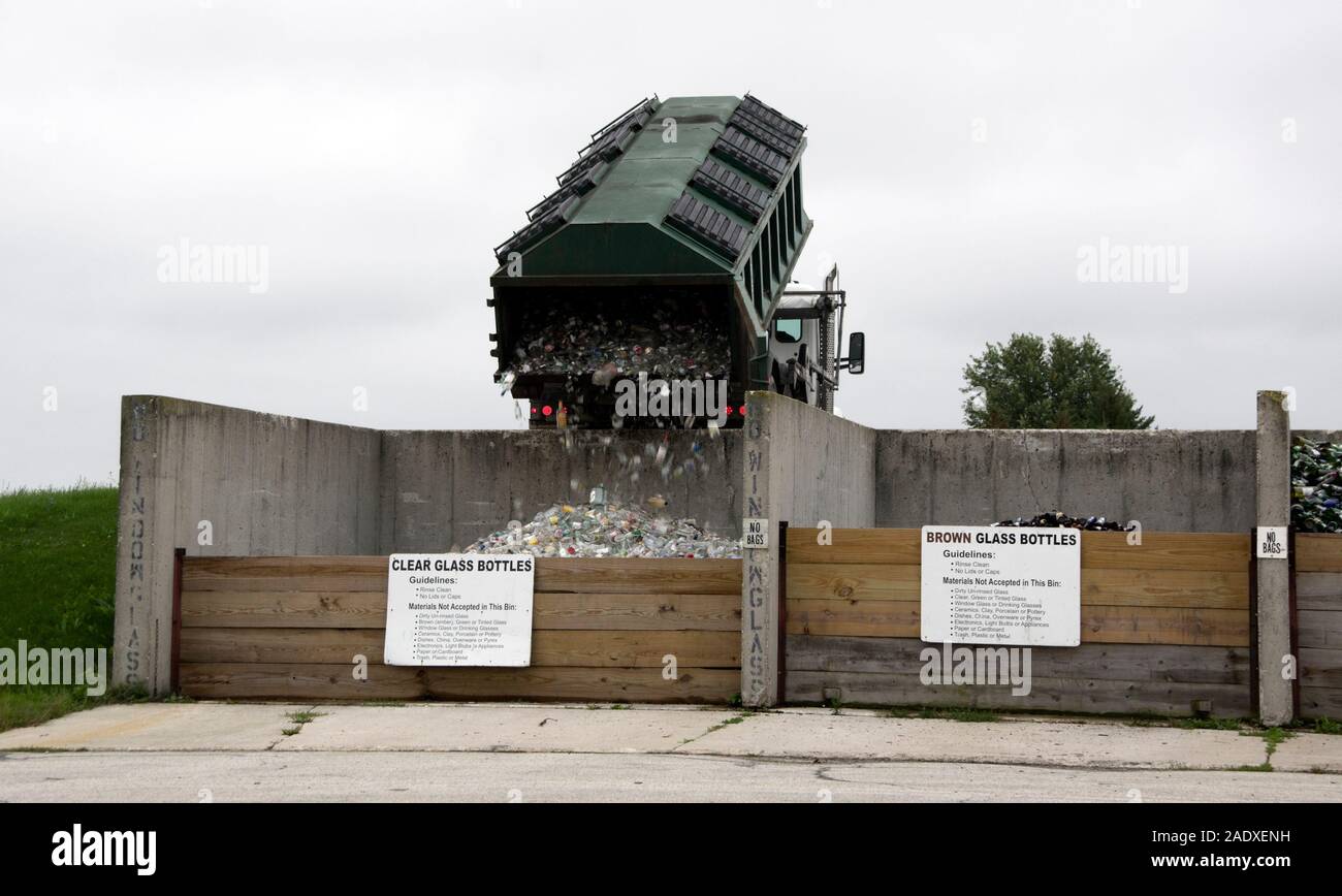 Local glass recycling container being emptied into receiving bin at recycling center. Stock Photo