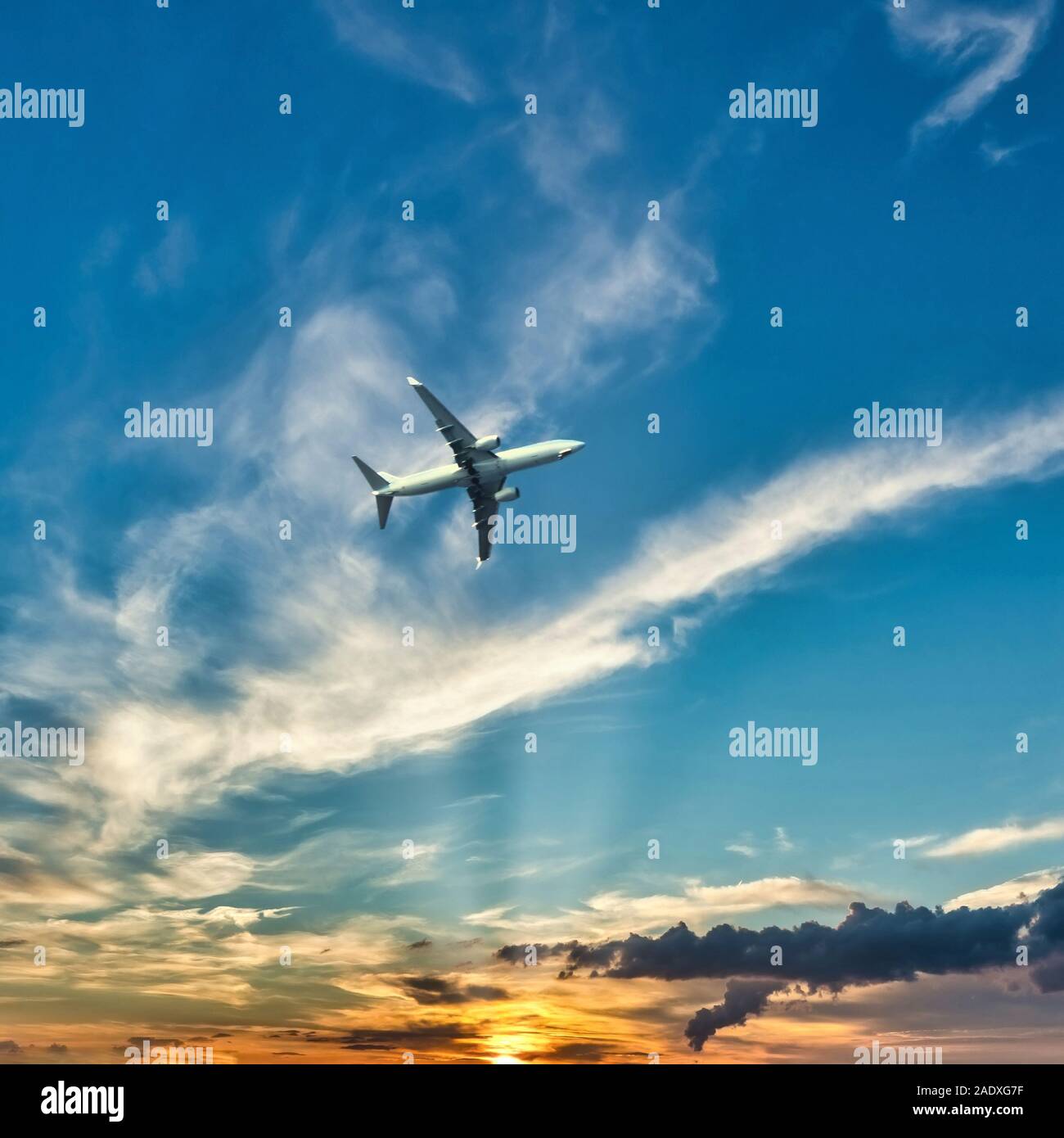 Square photo of big airplane above Kos island. Plane is captured from boath before landing. Sky is with sunset and dramatic clouds. Stock Photo
